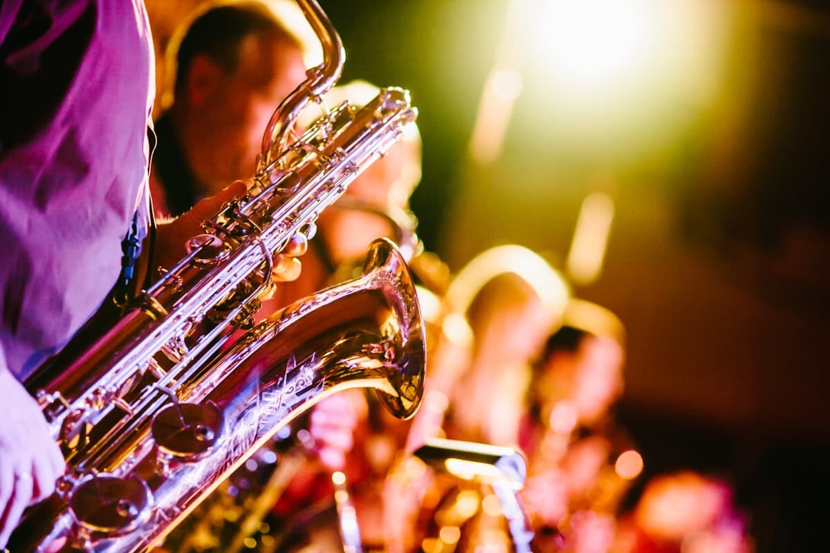 Horn section of a jazz band performing under warm golden stage light