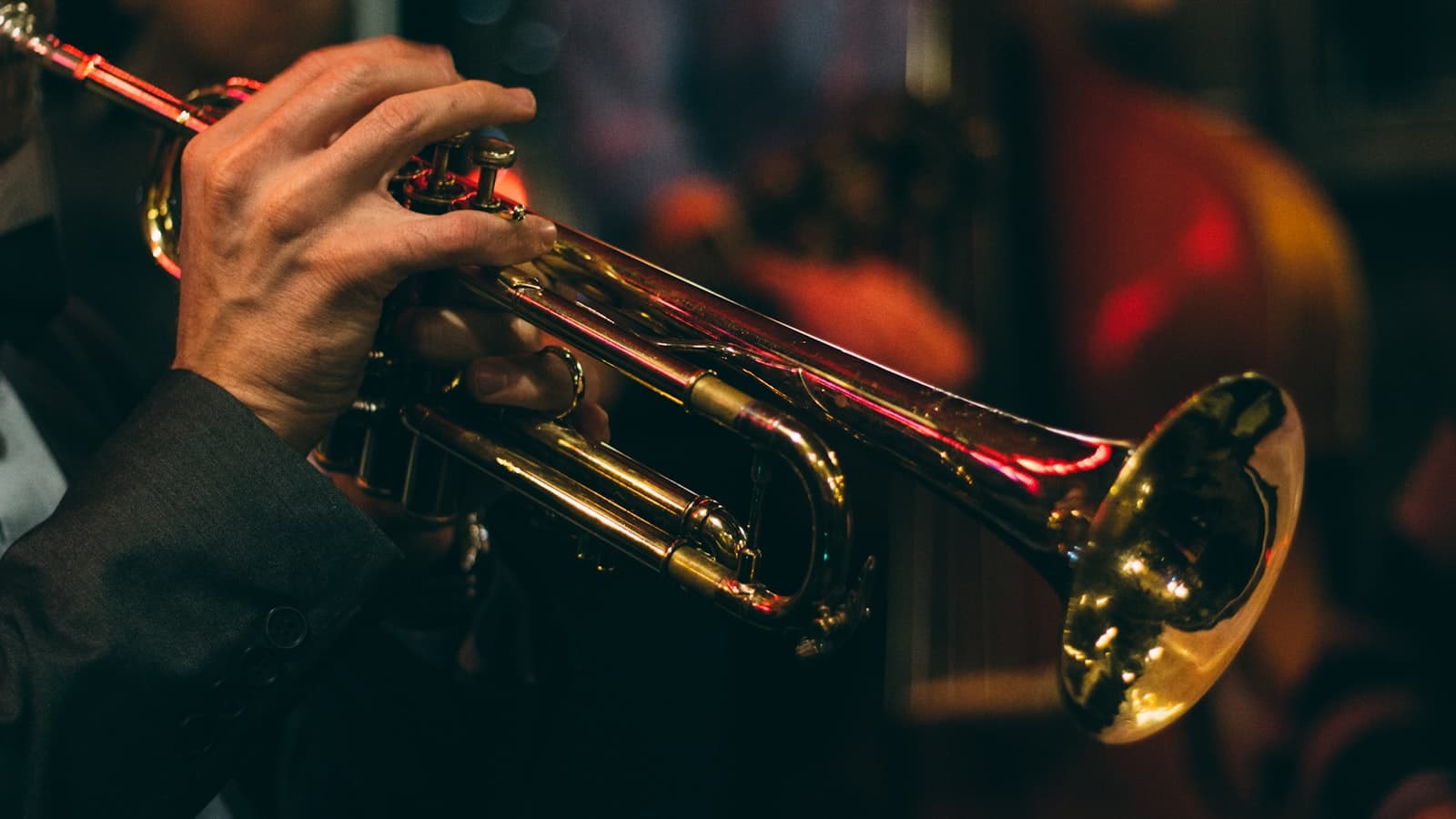 Close-up of a trumpet player's hands during a dimly lit jazz performance